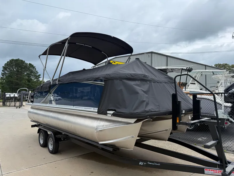 Slide: The Image of 2025 Avalon LSZ Quad Lounger Shift pontoon boat on trailer, covered and parked outdoors. - 3