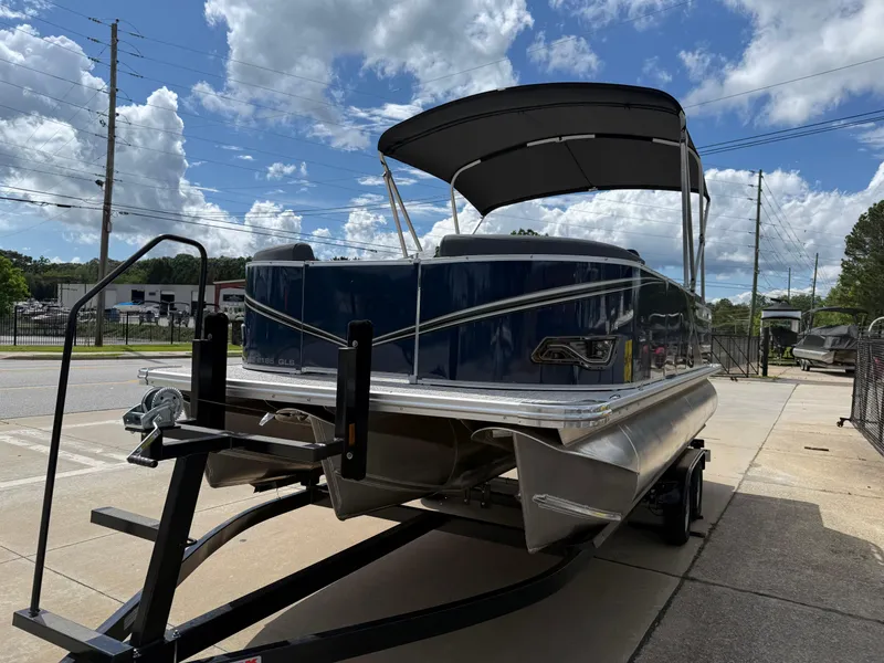 Slide: The Image of 2025 Avalon LSZ Quad Lounger Shift pontoon boat on trailer under cloudy sky. - 6