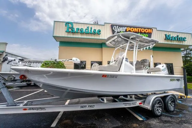 Slide: The Image of 2023 Sea Pro 228 Bay boat on trailer outside Paradise Marine store. - 1