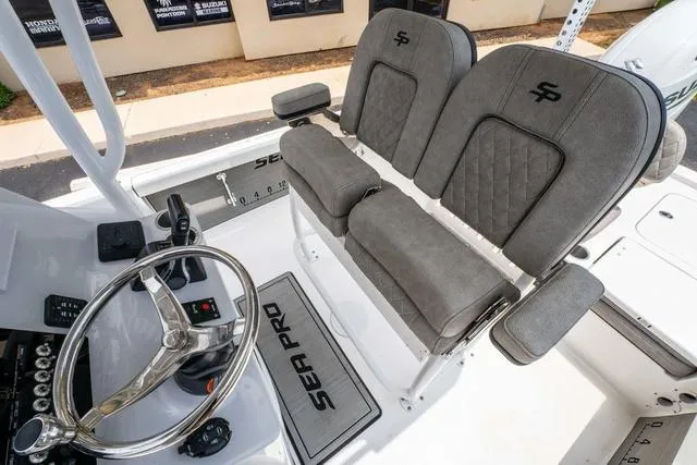Slide: The Image of 2023 Sea Pro 228 Bay boat interior with dual seats and steering wheel. - 10
