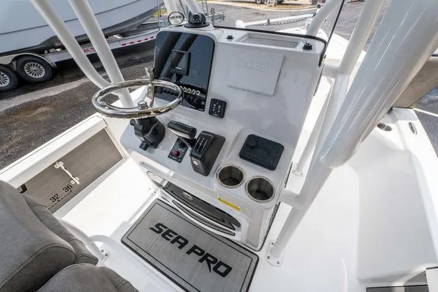 Slide: The Image of 2023 Sea Pro 228 Bay boat console with steering wheel and controls. - 13