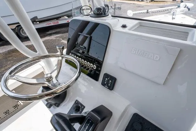 Slide: The Image of 2023 Sea Pro 228 Bay boat dashboard with steering wheel and Simrad navigation system. - 14