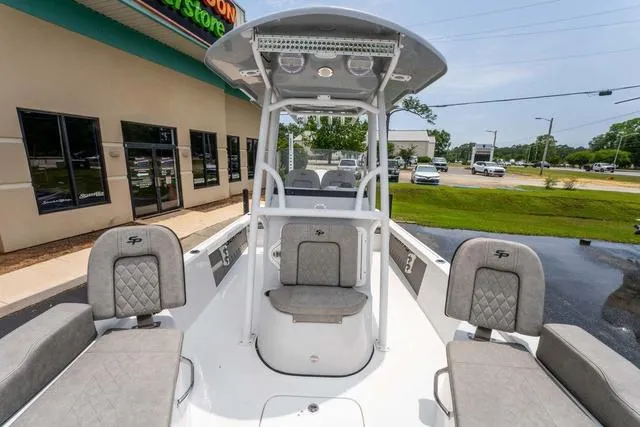 Slide: The Image of 2023 Sea Pro 228 Bay boat with seating and console, parked outside a store. - 19