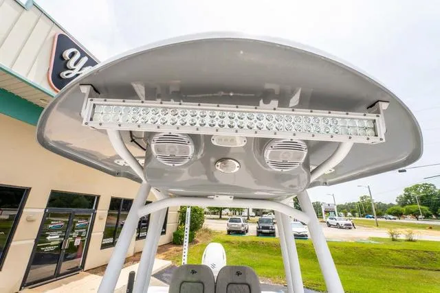 Slide: The Image of 2023 Sea Pro 228 Bay boat with T-top and LED light bar, parked near a building. - 20