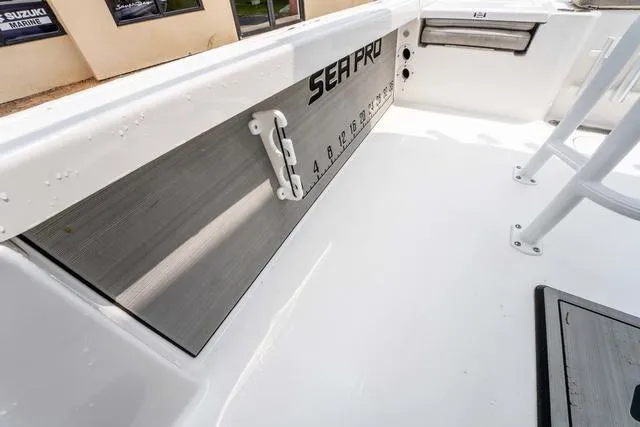 Slide: The Image of 2023 Sea Pro 228 Bay boat interior with measurement markings and storage compartment. - 23
