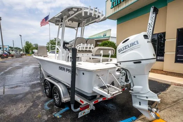 Slide: The Image of 2023 Sea Pro 228 Bay boat with Suzuki engine on trailer, parked outside. - 3