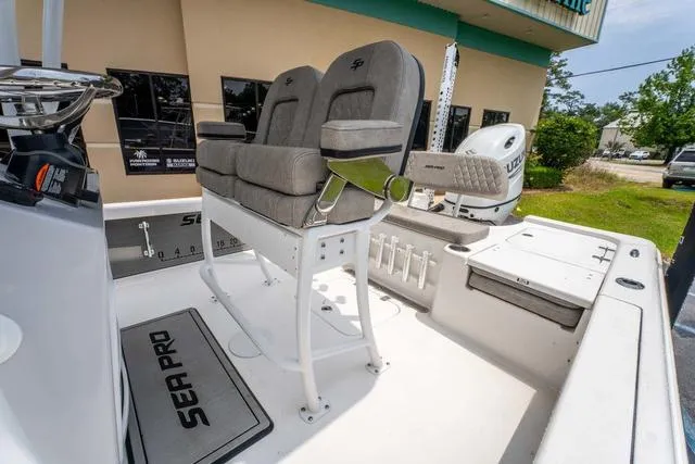 Slide: The Image of 2023 Sea Pro 228 Bay boat interior with cushioned seating and outboard motor. - 8