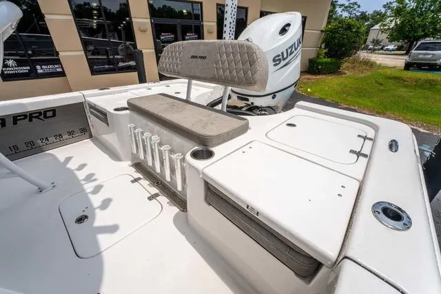 Slide: The Image of 2023 Sea Pro 228 Bay boat interior with seating, rod holders, and Suzuki engine. - 9
