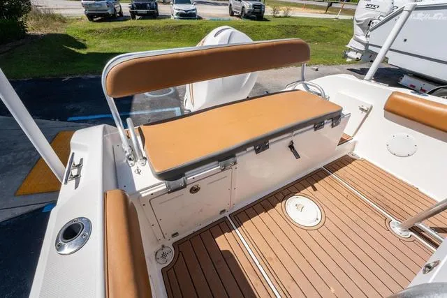 Slide: The Image of 2004 Cobia 234 boat interior with tan seating and wood-style flooring. - 11