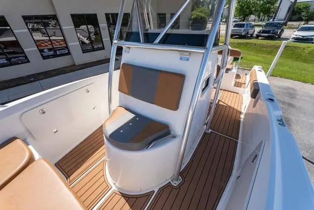 Slide: The Image of 2004 Cobia 234 boat interior with brown seating and wood-style flooring. - 16