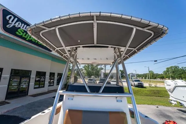 Slide: The Image of 2004 Cobia 234 boat with T-top, parked near a store, under clear blue sky. - 17
