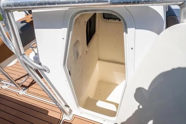 Slide: The Image of 2004 Cobia 234 boat interior cabin entrance with wooden deck and metal railing. - 18