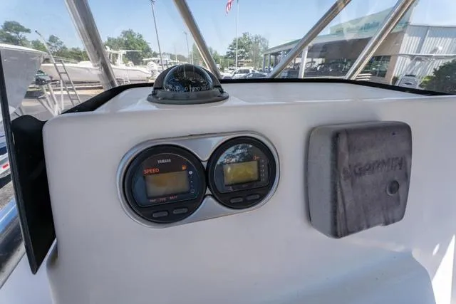 Slide: The Image of 2004 Cobia 234 boat dashboard with Yamaha gauges and compass. - 21