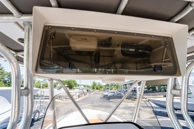 Slide: The Image of 2004 Cobia 234 boat console with electronics and storage, featuring a clear protective cover. - 22