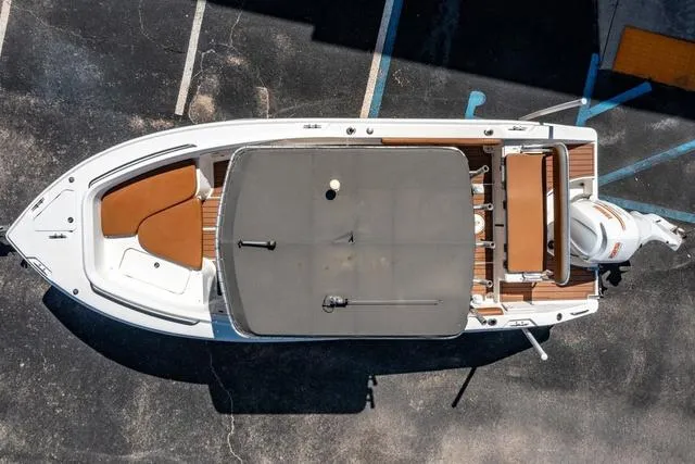 Slide: The Image of Aerial view of 2004 Cobia 234 boat with canopy and seating, parked on asphalt. - 23