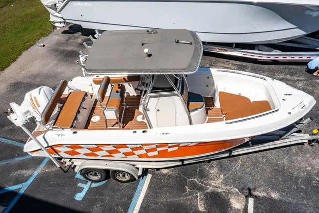 Slide: The Image of 2004 Cobia 234 boat with orange checkered design on trailer, aerial view. - 24