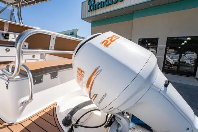 Slide: The Image of 2004 Cobia 234 boat with 225 horsepower outboard motor, displayed outside a building. - 4