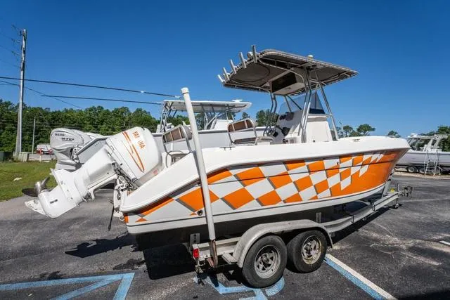 Slide: The Image of 2004 Cobia 234 boat with orange checkered design on a trailer, parked outdoors. - 5