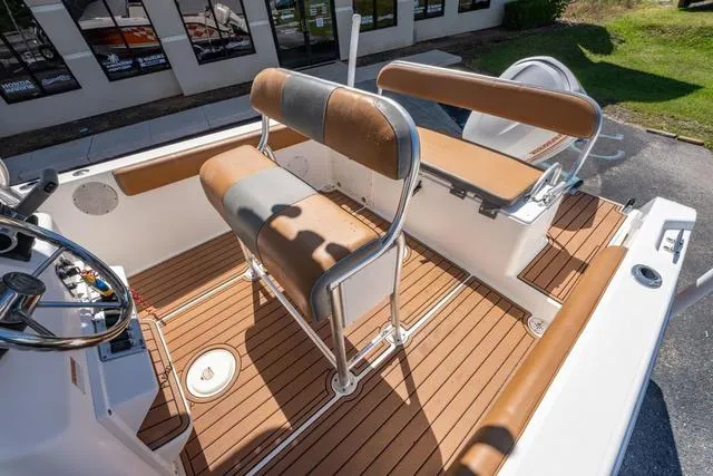 Slide: The Image of 2004 Cobia 234 boat interior with tan seating and wood-style flooring. - 9