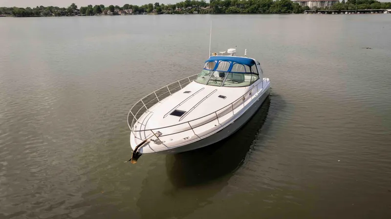 Slide: The Image of 1998 Sea Ray Sundancer 400 yacht on calm water, featuring sleek design and blue canopy. - 13