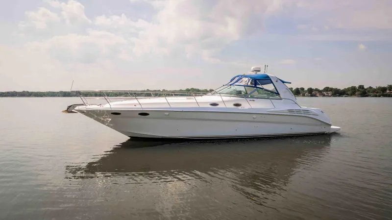 Slide: The Image of 1998 Sea Ray Sundancer 400 yacht on calm water under a cloudy sky. - 16