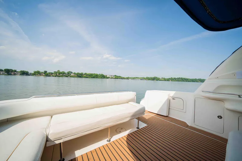 Slide: The Image of 1998 Sea Ray Sundancer 400 yacht deck with white seating, overlooking calm waters and clear sky. - 19