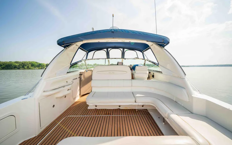 Slide: The Image of 1998 Sea Ray Sundancer 400 yacht with spacious deck and blue canopy on calm water. - 22