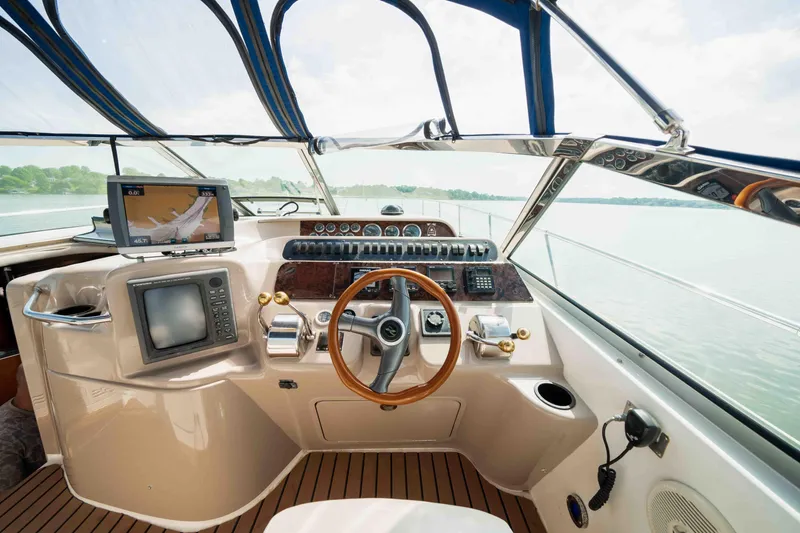 Slide: The Image of 1998 Sea Ray Sundancer 400 helm with navigation equipment and wooden steering wheel. - 23