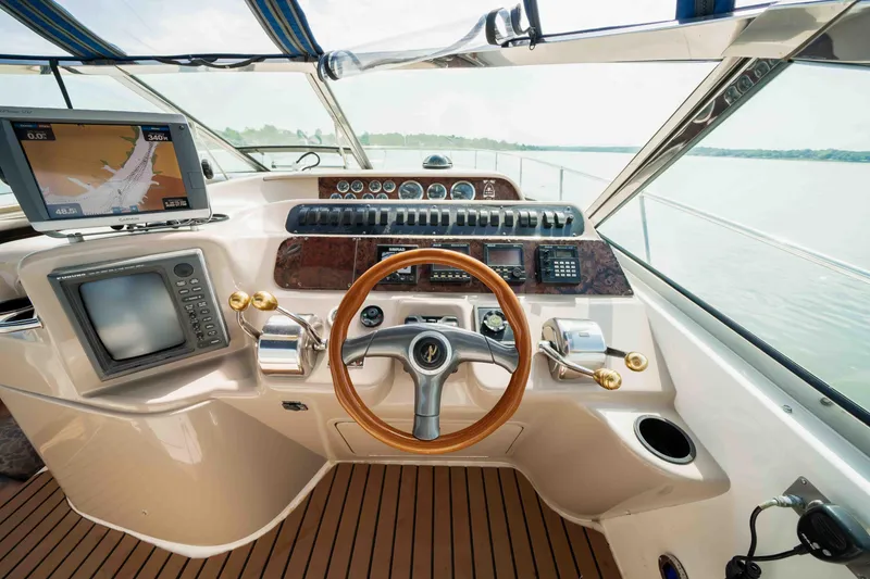 Slide: The Image of 1998 Sea Ray Sundancer 400 helm with wooden steering wheel and navigation equipment. - 24