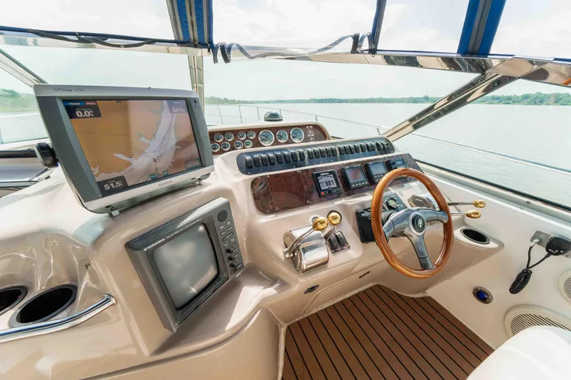 Slide: The Image of 1998 Sea Ray Sundancer 400 helm with navigation screens and wooden steering wheel. - 26
