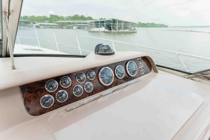 Slide: The Image of 1998 Sea Ray Sundancer 400 dashboard with gauges, overlooking a serene marina view. - 28