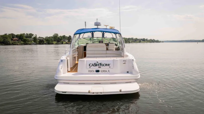Slide: The Image of 1998 Sea Ray Sundancer 400 yacht on calm water, rear view with blue canopy. - 4