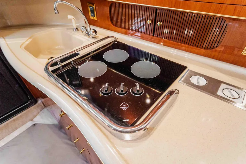 Slide: The Image of 1998 Sea Ray Sundancer 400 kitchen with stove and sink, featuring sleek design and modern amenities. - 42