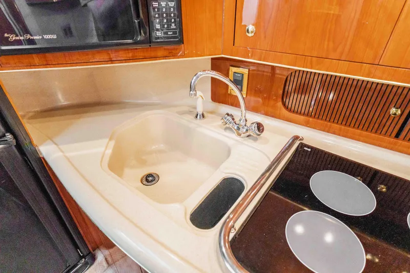 Slide: The Image of 1998 Sea Ray Sundancer 400 kitchen with sink, stove, and microwave. - 43