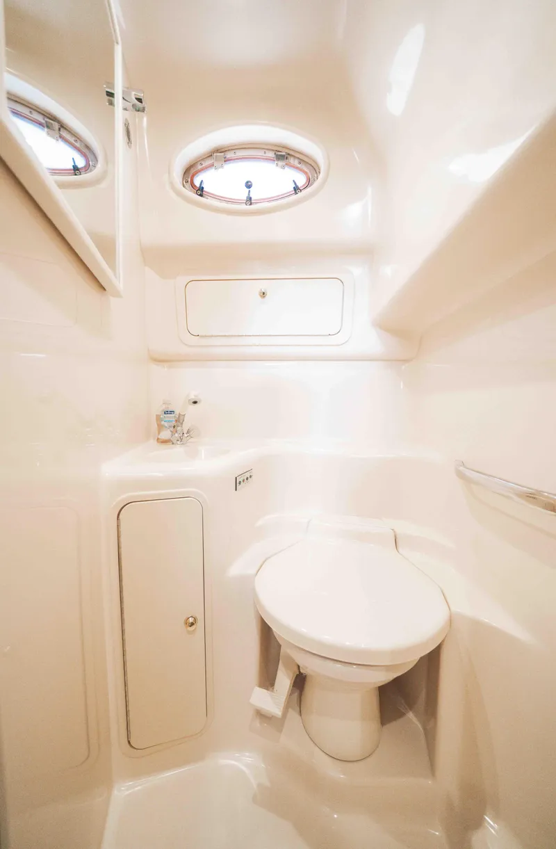 Slide: The Image of 1998 Sea Ray Sundancer 400 yacht bathroom with compact design and porthole window. - 45