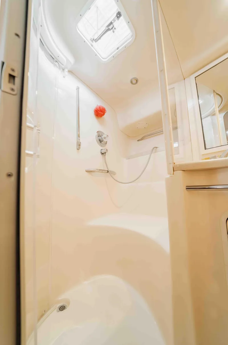 Slide: The Image of 1998 Sea Ray Sundancer 400 yacht bathroom with shower, white interior, and skylight. - 49