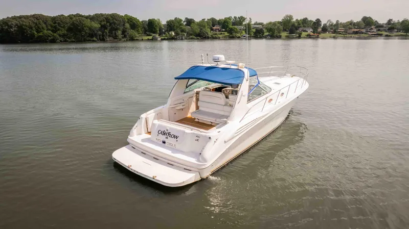 Slide: The Image of 1998 Sea Ray Sundancer 400 yacht with blue canopy on a calm lake. - 6