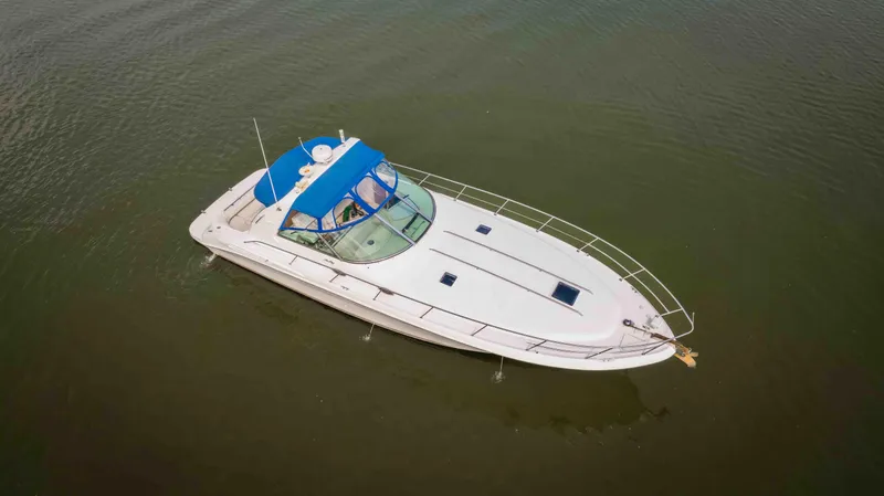 Slide: The Image of 1998 Sea Ray Sundancer 400 yacht with blue canopy on calm water. - 8