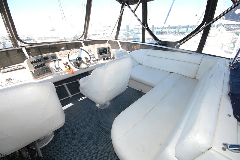 Slide: The Image of 2005 Regal Commodore 3880 yacht cockpit with white seating and control panel. - 13