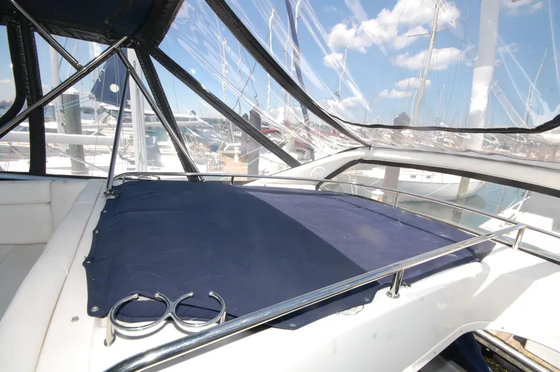 Slide: The Image of 2005 Regal Commodore 3880 yacht deck with blue cover and marina view. - 14