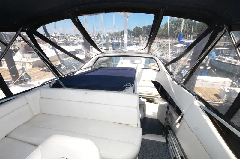 Slide: The Image of 2005 Regal Commodore 3880 yacht interior with white seating and marina view. - 15