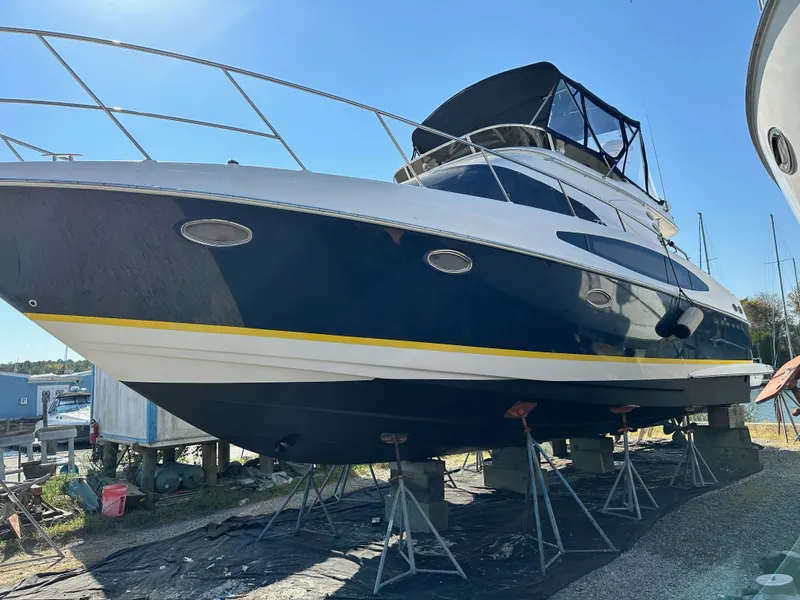 Slide: The Image of 2005 Regal Commodore 3880 yacht on stands, blue hull, marina setting. - 40