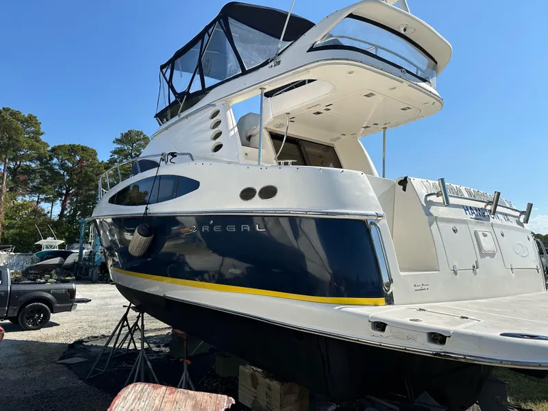 Slide: The Image of 2005 Regal Commodore 3880 yacht on dry dock, blue and white exterior, sunny day. - 42