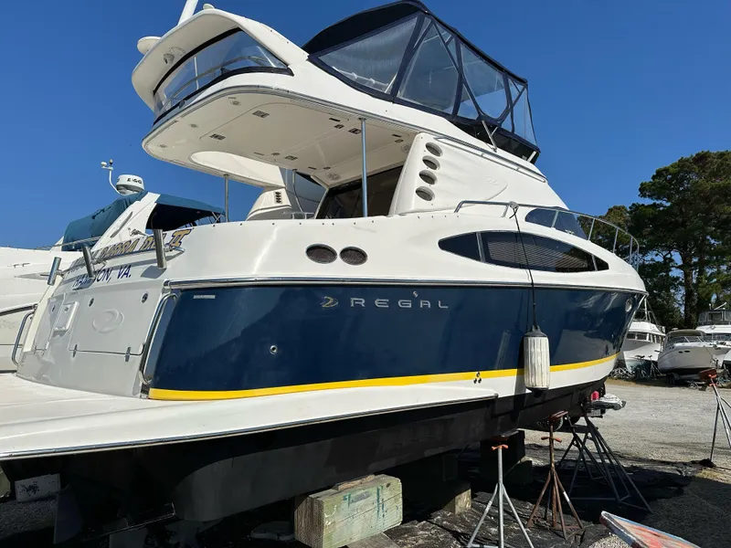Slide: The Image of 2005 Regal Commodore 3880 yacht on dry dock, blue and white exterior. - 43
