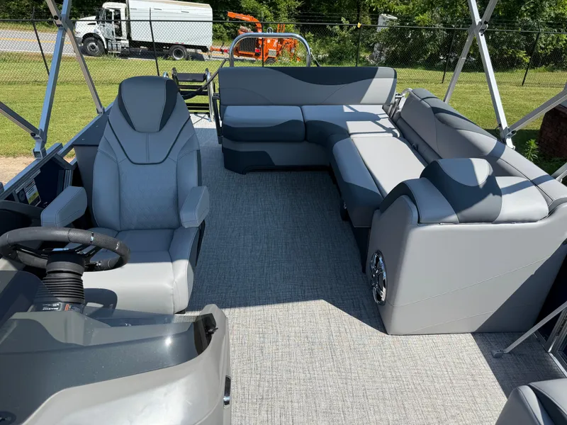 Slide: The Image of 2025 Avalon LSZ Cruise Bench interior with gray seating and steering wheel, parked outdoors. - 25