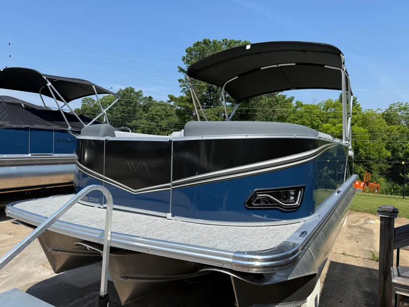 Slide: The Image of 2025 Avalon LSZ Cruise Bench pontoon boat with canopy, docked outdoors on a sunny day. - 3
