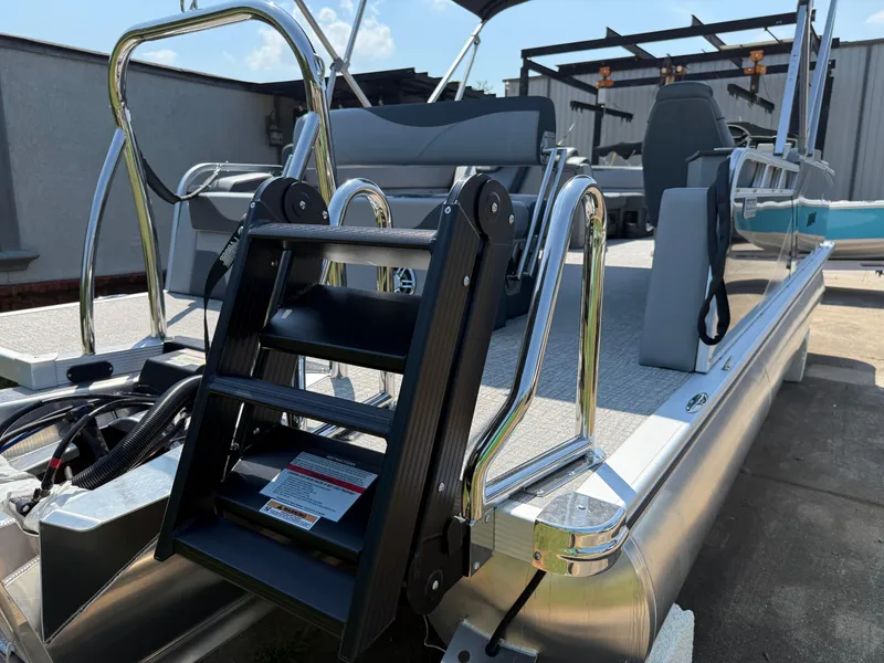 Slide: The Image of 2025 Avalon LSZ Cruise Bench pontoon boat with ladder and seating, docked outdoors. - 47