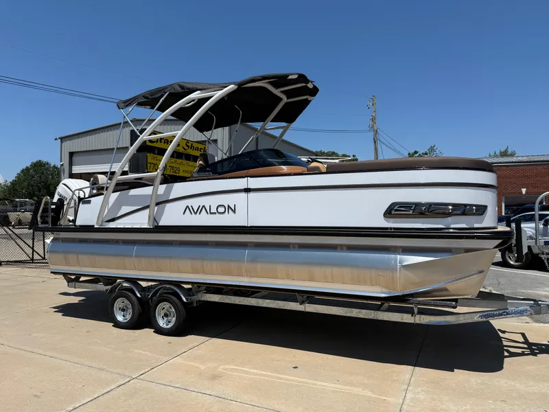 The Image of 2025 Avalon Catalina Quad Lounger Windshield pontoon boat on trailer, parked outdoors. - 0