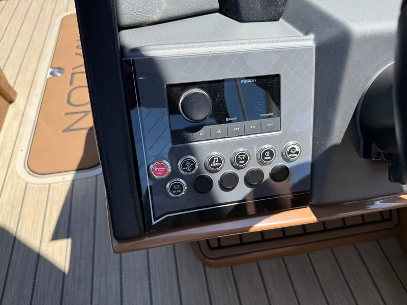 Slide: The Image of Control panel of 2025 Avalon Catalina Quad Lounger Windshield boat with audio system and buttons. - 28