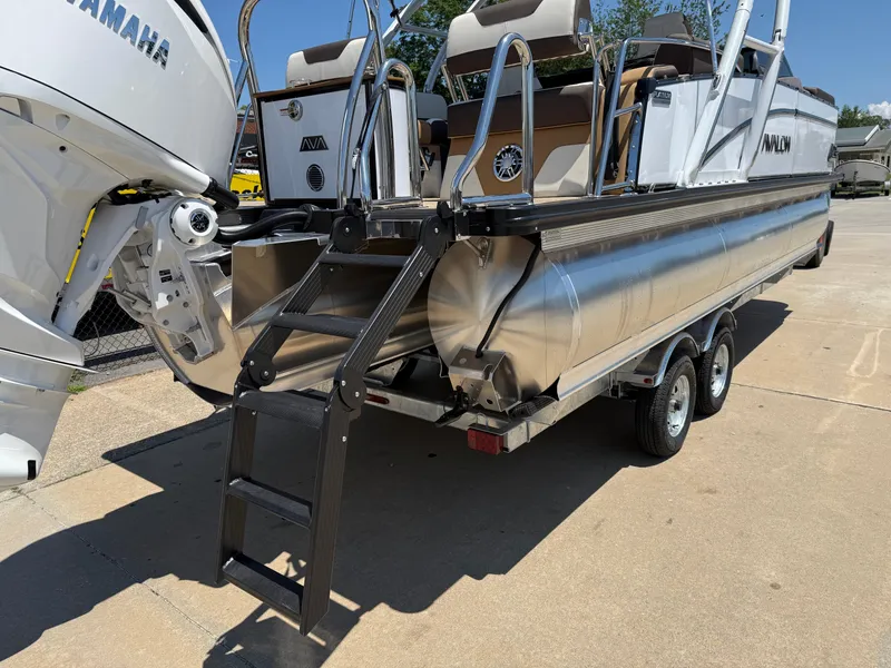 Slide: The Image of 2025 Avalon Catalina Quad Lounger Windshield boat on trailer, featuring Yamaha engine and rear ladder. - 7